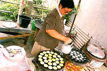 Mujer thai preparando dulces de leche de coco, Tailandia