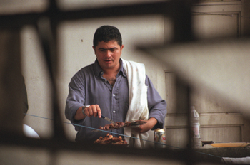 Hombre haciendo una barbacoa, favela de Sao Paulo, Brasil