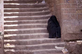 Mujer descansando en unas escaleras en Ibb, Yemen