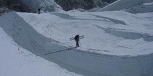 Escalador cruzando una grieta en un glaciar con una escalera