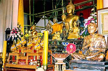 Templo budista con altar lleno de Budas y ofrendas, Chiang Mai,