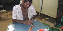 Artesano aborigen pintando un boomerang, Australia