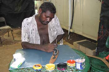 Artesano aborigen pintando un boomerang, Australia