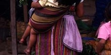 Mujer con niño a la espalda en el mercado de Antigua, Guatemala