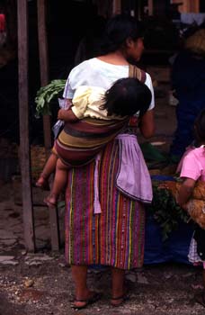 Mujer con niño a la espalda en el mercado de Antigua, Guatemala