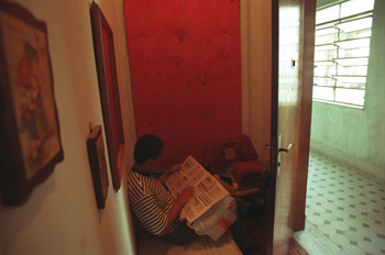 Hombre leyendo un periódico, favela de Sao Paulo, Brasil