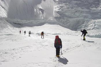 Fila de escaladores escalando a lo largo de una cuerda fija