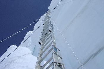 Escalera suspendida contra la pared de hielo con cuerdas