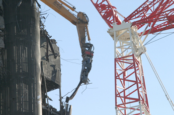 Grúa que ha demolido el edificio Windsor, en acción en la cima d