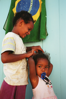 Niña peinando a su hermana, favela de Sao Paulo, Brasil