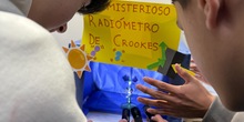Un par de adolescentes realiza un experimento con el radiómetro de Crookes en el stand del IES Enrique Tierno Galván de Parla