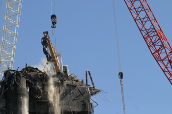 Grúa que ha demolido el edificio Windsor, en acción en la cima d