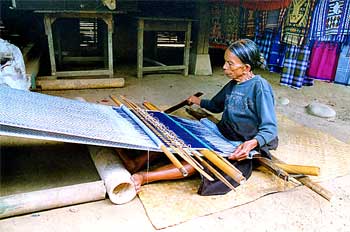 Mujer trabajando en telar artesanal, Sulawesi, Indonesia