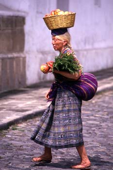 Mujer con cesta en la cabeza en el mercado de Antigua, Guatemala