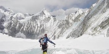 Escalador cruzando una grieta en un glaciar con una escalera