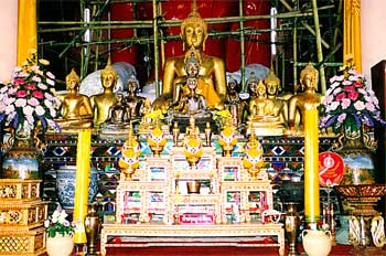 Altar budista decorado con imágenes de budas, presentes y velas,
