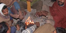 Hombres sentados alrededor del fuego
