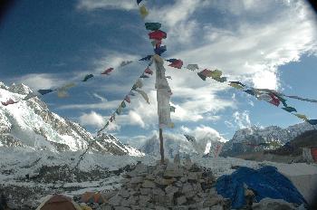 Puja: montículo de piedra, poste y banderas de oración
