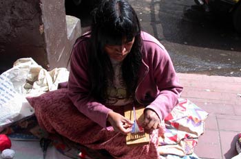 Mujer sentada realizando un trabajo artesanal