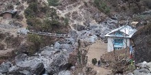 Sendero con casa, río y puente