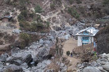 Sendero con casa, río y puente