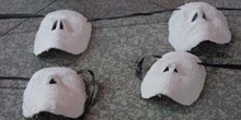 Cuatro máscaras blancas sobre el suelo