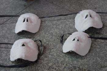 Cuatro máscaras blancas sobre el suelo