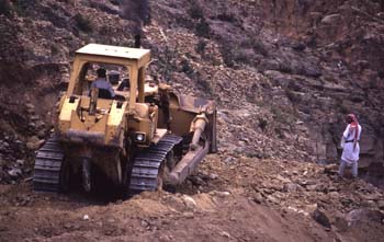Excavadora trabajando en la ruta de acceso a Shahara, Yemen