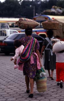 Mujer con niño a la espalda de regreso del mercado de Antigua, G
