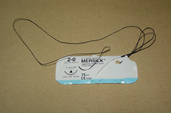 Seda de sutura con aguja curva