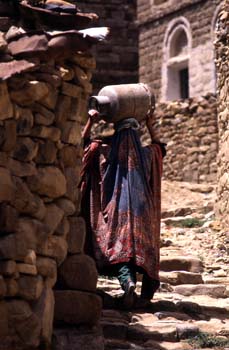 Mujer llevando una botella de gas sobre la cabeza, Yemen