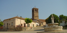 Plaza con fuente e iglesia al fondo en Ribatejada