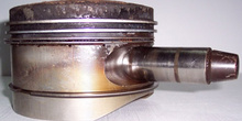 Pistón de un motor completo corroído y erosionado