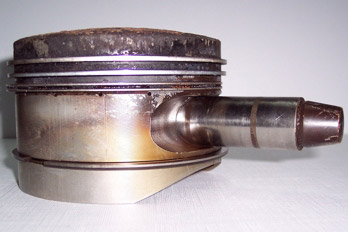 Pistón de un motor completo corroído y erosionado