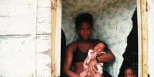 Mujer enseña su bebé recién nacido, favelas de Rio de Janeiro, B