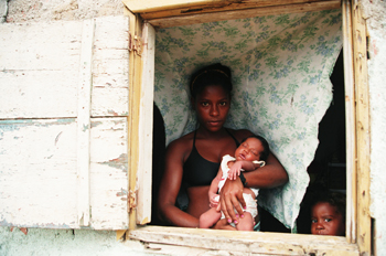 Mujer enseña su bebé recién nacido, favelas de Rio de Janeiro, B