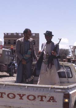 Dos hombres armados en un mercado de qat, con jambia, Yemen