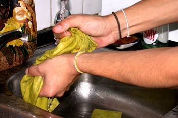 Manos escurriendo bayeta de cocina