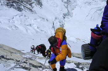 Escaladores bajando una pendiente con cuerda fija