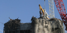 Grúa que ha demolido el edificio Windsor, en acción en la cima d