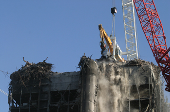 Grúa que ha demolido el edificio Windsor, en acción en la cima d