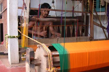 Hombre hindú trabajando un sari en un telar