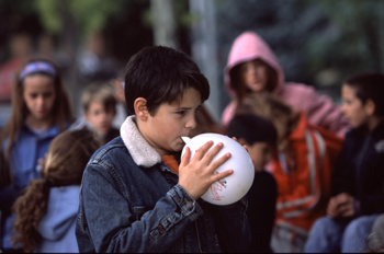 Niño inflando un globo