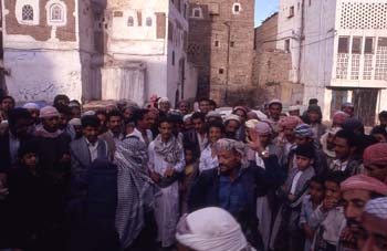 Corro de hombres contemplando un espectáculo improvisado de bail