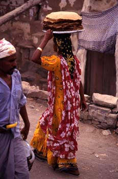Mujer llevando tortas de pan en el mercado de Suq al Khamis, Yem