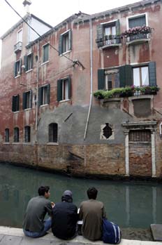 Chicos comiendo en un canal de Venecia