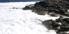 Rompiendo olas en acantilado