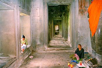 Anciana budista atendiendo altar de Buda, Angkor, Camboya