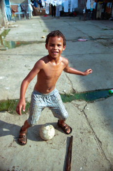 Niño jugando al balón, favelas de Sao Paulo, Brasil