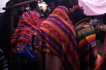 Tres mujeres protegiéndose de la lluvia en el mercado de Chichic